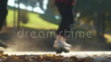 青少年滑板运动员在公园的落叶上骑滑板。 关注前景。 慢动作。